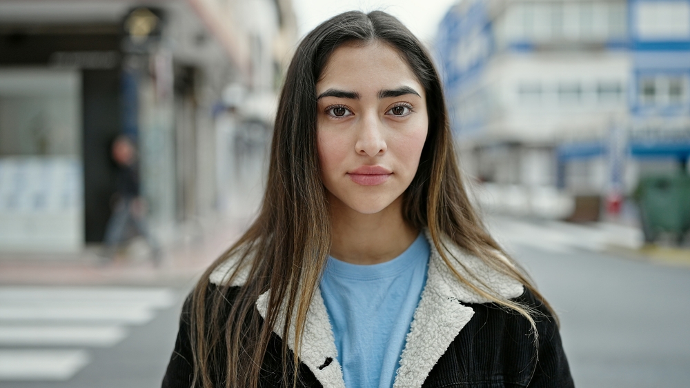 Young,Beautiful,Hispanic,Woman,Standing,With,Serious,Expression,At,Street